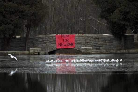 A sign reading ‘Pray for Newtown’ hangs from a stone bridge over Hawley Pond in Newtown, Connecticut USA, 16 December 2012. EPA/PETER FOLEY